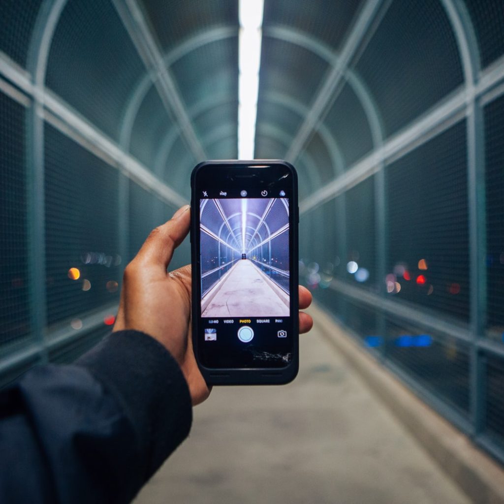 person holding phone showing empty tunnel